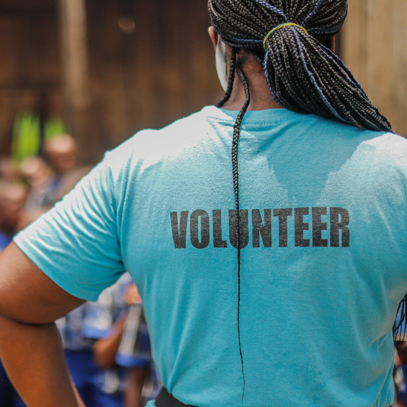 Woman wearing a blue t-shirt with 'Volunteer' written on the back. 