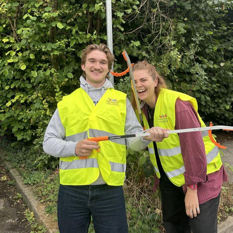 Lucy Neville and her friend at a recent St Albans litter pick, smiling and holding grabbers, wearing hi-vis vests.